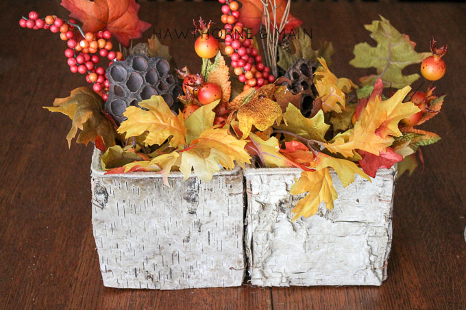 Fall is in the air, or will be soon! Here is a woodsy fall centerpiece piece that is the perfect mix of rustic with a tradition fall feel.  I love the aspen box!