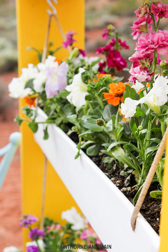 DIY Hanging Gutter Planter. This is a really fun and easy afternoon project that is sure to brighten up your outdoor space. 