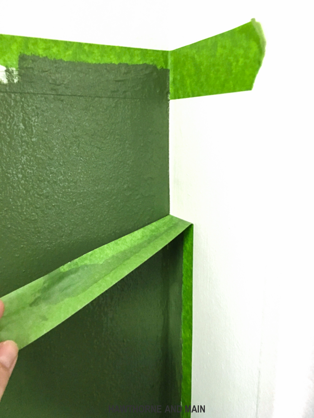 pulling-off-frog-tape-on-a-green-wall